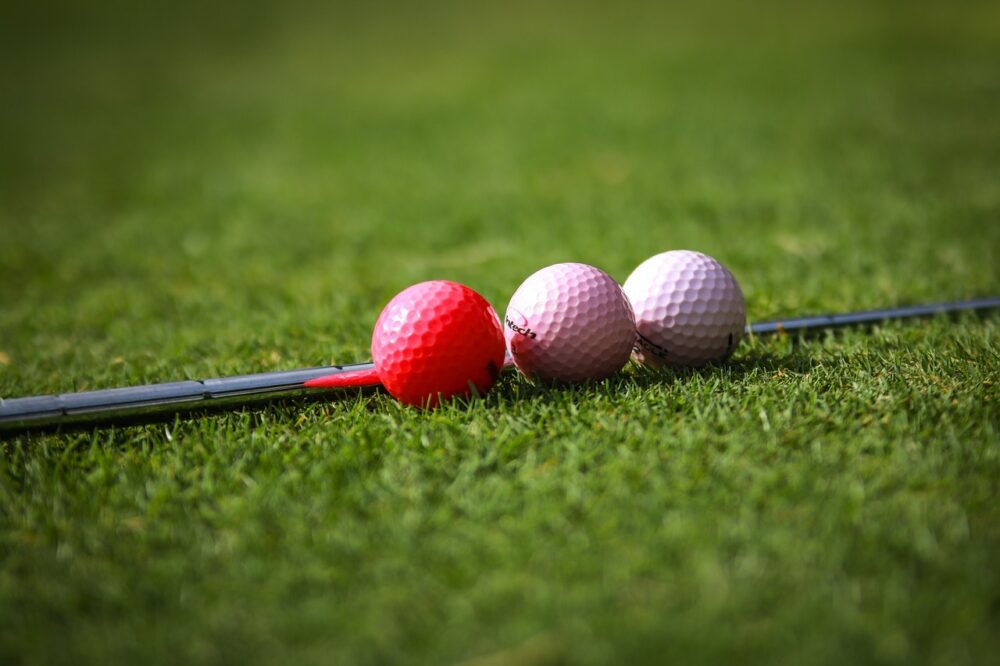 pink-golf-ball-and-golf-club-on-the-green