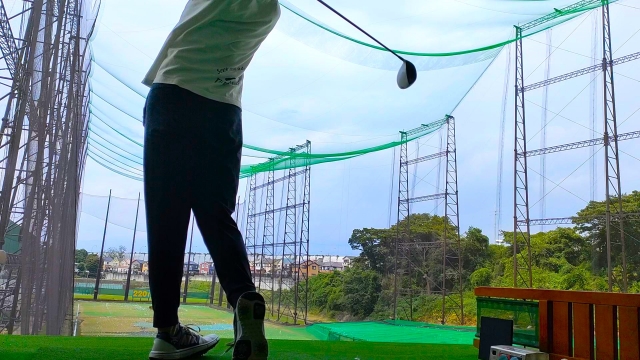 A-man-practicing-at-a-golf-driving-range